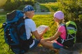 Man and girl with backpack resting and looking at map Royalty Free Stock Photo