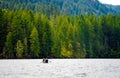 Man with girl and dog sail on boat along the picturesque mountain lake of Merwin with forest of green beaches