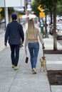 Man and girl with dog walking on the streets of the modern city