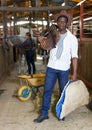 Man and girl harnessing horse in stable Royalty Free Stock Photo