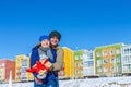 Man and the girl hug on a background of colored houses with gift Royalty Free Stock Photo