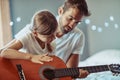 Man, girl and kid in guitar teaching and learning at home, bonding with love and creativity. Family, father and daughter Royalty Free Stock Photo