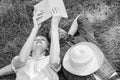 Man and girl lay on grass having fun. Couple in love spend leisure reading book. Couple soulmates at romantic date Royalty Free Stock Photo