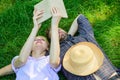 Man and girl lay on grass having fun. Couple in love spend leisure reading book. Couple soulmates at romantic date Royalty Free Stock Photo