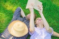 Man and girl lay on grass having fun. Couple in love spend leisure reading book. Couple soulmates at romantic date Royalty Free Stock Photo