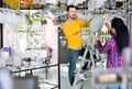 Man and girl in lighter shop choosing modern round glass ceiling lamp for house Royalty Free Stock Photo