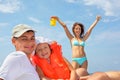 Man with girl in orange lifejacket and woman