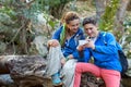 Man and Girl sitting in Forest and looking at Telephone Screen Royalty Free Stock Photo