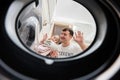 Man and girl view from washing machine inside. Father with daughter does laundry daily routine Royalty Free Stock Photo