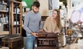 Man with girlfriend admiring vintage wooden bureau