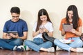 Man and girls friend classmates sitting useing technology Royalty Free Stock Photo