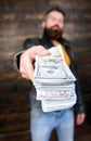 Man give cash money bribe. Richness and wellbeing. Mafia business. Man brutal bearded hipster wear leather jacket and Royalty Free Stock Photo
