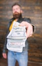 Man give cash money bribe. Richness and wellbeing. Mafia business. Man brutal bearded hipster wear leather jacket and Royalty Free Stock Photo