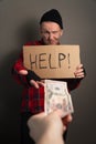 Man gives alms to the homeless. unemployed takes money for a living. cardboard begging. vertical shot