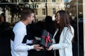 Man gives beautiful brunette gift. Young happy couple with gift box Royalty Free Stock Photo