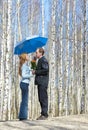 Man gives girl bouquet under umbrella Royalty Free Stock Photo