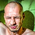 A man gives himself a cold shower after work to calm down after hard frustrated and nervous day at his job close up