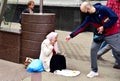 A man gives money to a homeless elderly woman. Grandma begs for alms. Old woman begging on the street. Homeless beggar asking for