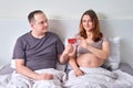 A man gives a pregnant woman a bank card. Husband gives his wife a credit card during her pregnancy