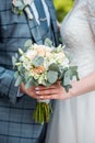 Man gives wedding flowers girl. Close-up. Wedding bouquet. Beautiful bridal bouquet in hands of young bride dressed in white weddi Royalty Free Stock Photo