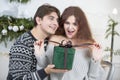A man gives a woman a Christmas present. Husband and wife in the New Year holidays Royalty Free Stock Photo