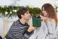 A man gives a woman a Christmas present. Husband and wife in the New Year holidays Royalty Free Stock Photo