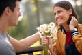 Man giving bouquet of flowers to a woman; Happy couple concept