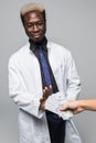 Man giving bribe to a afro american doctor refusing the money, isolated on gray background Royalty Free Stock Photo