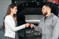 Man giving client keys to her repaired car in auto repair service Royalty Free Stock Photo