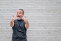 Man giving a double thumbs up gesture in front of a white brick wall Royalty Free Stock Photo