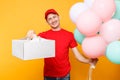 Man giving food order cake box isolated on yellow background. Male employee courier in red cap t-shirt hold colorful air