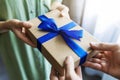 Man giving gift box with blue ribbon to woman Royalty Free Stock Photo
