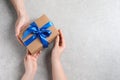 Man giving gift box to woman on light gray background, top view. Space for text Royalty Free Stock Photo