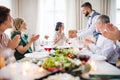 A man giving gift to a young surprised woman on a family birthday party. Royalty Free Stock Photo