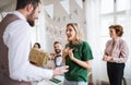 A man giving gift to a young surprised woman on a family birthday party. Royalty Free Stock Photo