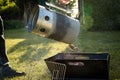 Man giving glowing hot charcoal coals from starting chimney in foldable barbecue grill for BBQ outside Royalty Free Stock Photo