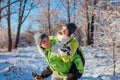 Man giving his girlfriend piggyback in winter forest. Couple in love having fun Royalty Free Stock Photo