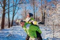 Man giving his girlfriend piggyback in winter forest. Couple in love having fun Royalty Free Stock Photo