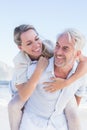 Man giving his smiling wife a piggy back at the beach Royalty Free Stock Photo