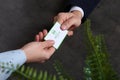 Man giving medical business card to woman on dark background. Nephrology service