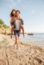 Man giving piggy back ride to his girlfriend at beach Royalty Free Stock Photo