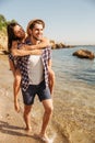 Man giving piggy back ride to his girlfriend at beach Royalty Free Stock Photo