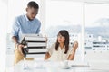 Man giving pile of files to his exasperated colleague