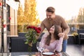 Man giving roses to his girlfriend on romantic date in cafe