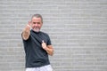 Man giving a thumb up gesture in front of a white brick wall Royalty Free Stock Photo