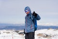 Man giving thumb up after peak summit trekking achievement in snow mountain