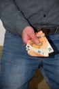 Man giving a wad of paper euro banknotes.