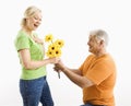 Man giving woman bouquet.