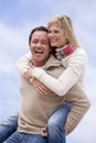 Man giving woman piggyback ride outdoors smiling