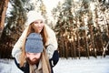 Man giving woman piggybacks ride on winter vacation in a snowy forest